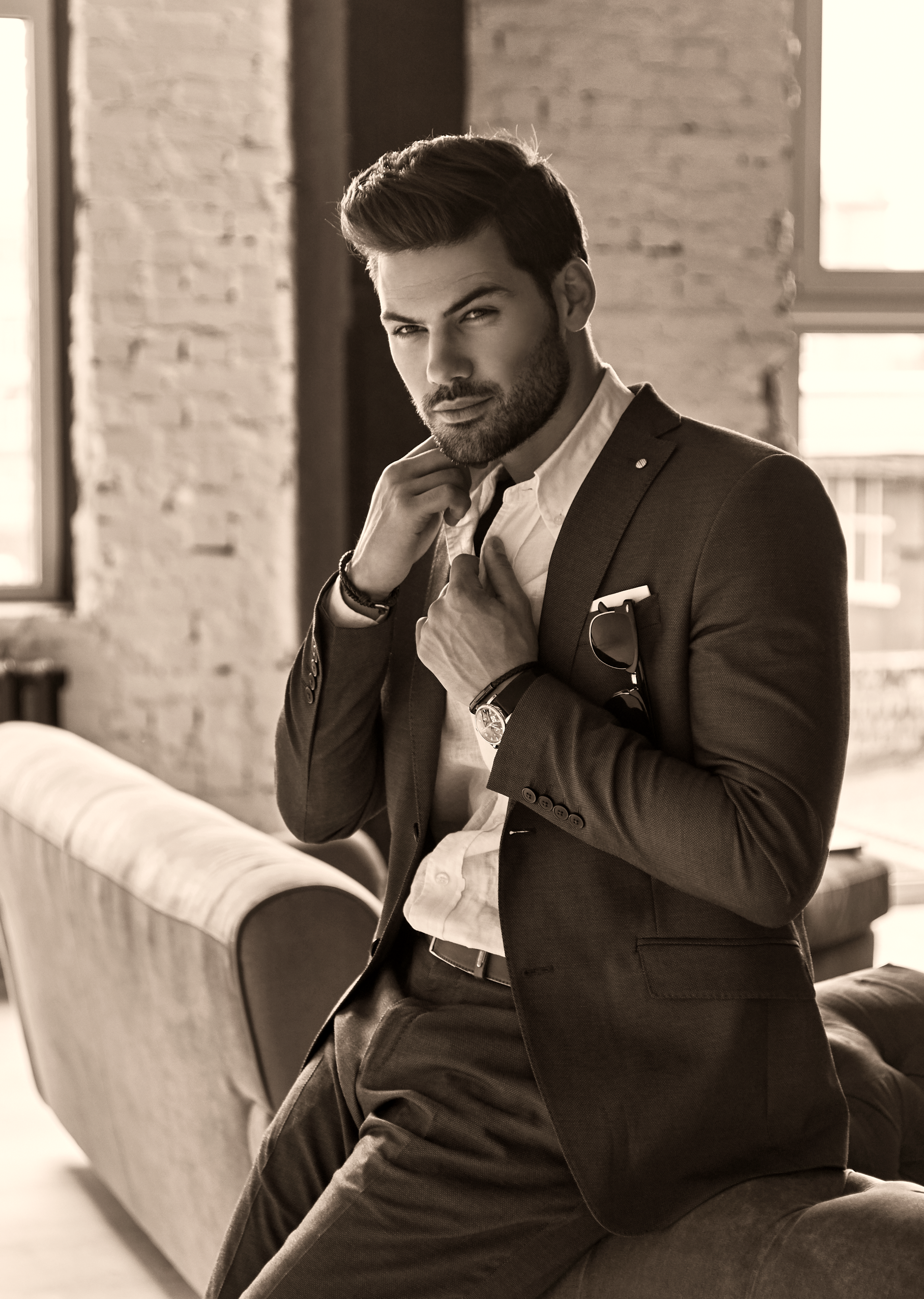 Man in a suit sitting on a couch in a stylish interior setting